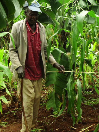 A man using using a string rope as a guidance for orientation in a field