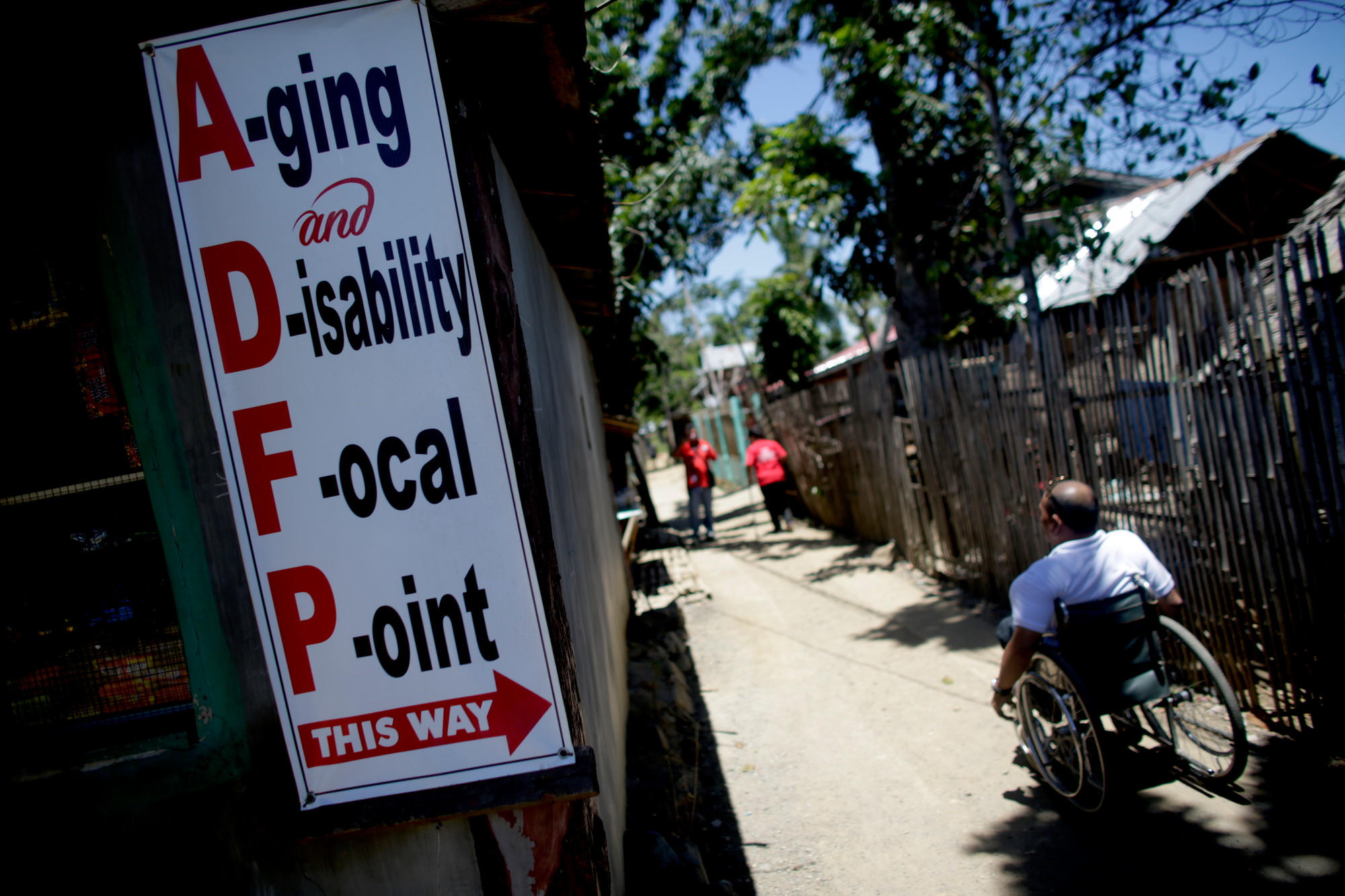 Man in a wheelchair in an alley going up to the Ageing and Disability Focal Point