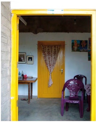 Doorway to a room, where the door frame is painted yellow