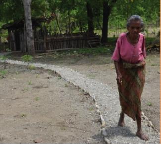 Une femme marchant sur un chemin balisé, délimité par de petites pierres comme garde-corps et conseils